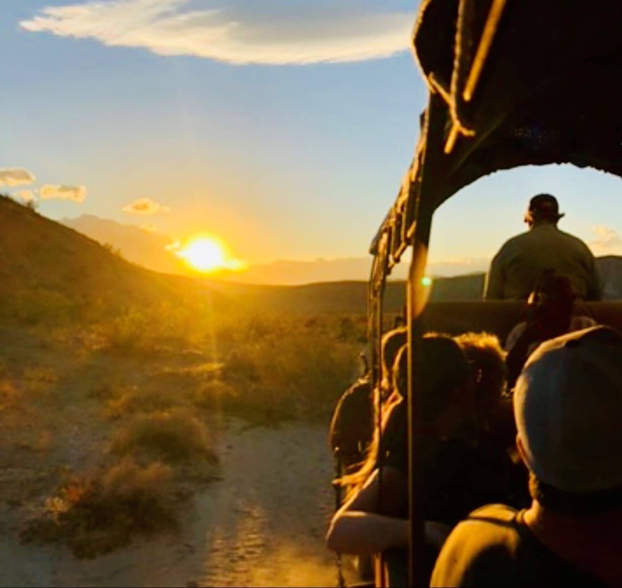 Guests riding in a covered wagon at sunrise in the Coachella Valley near Palm Springs